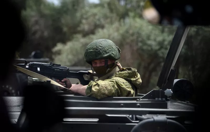 Russian soldiers patrol as a Russian military convoy in a small Syrian village near the city of Hama on May 4, 2016. - Syria's conflict erupted in 2011 after anti-government protests were put down. Fighting quickly escalated into a multi-faceted war that has killed more than 270,000 people and forced millions from their homes. (Photo by Vasily Maximov / AFP) / MOY