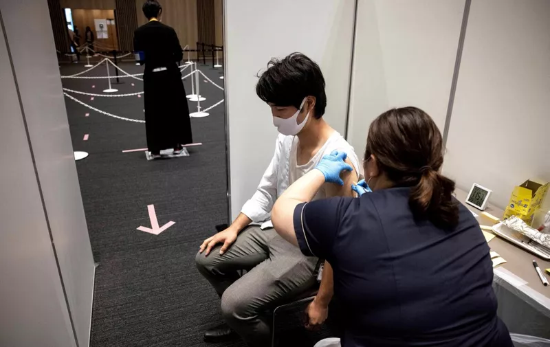 An employee of Japan's Mori Building Company, a property management firm, receives the Moderna coronavirus vaccine for Covid-19 during the company's workplace vaccination campaign in Tokyo on June 21, 2021. (Photo by Behrouz MEHRI / AFP)