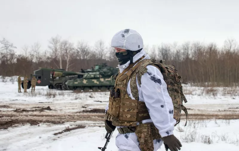 A Ukrainian Military Forces serviceman of the 92nd mechanised brigade walks in a field during live-fire exercises near the town of Chuguev, Kharkiv region on February 10, 2022. (Photo by Sergey BOBOK / AFP)