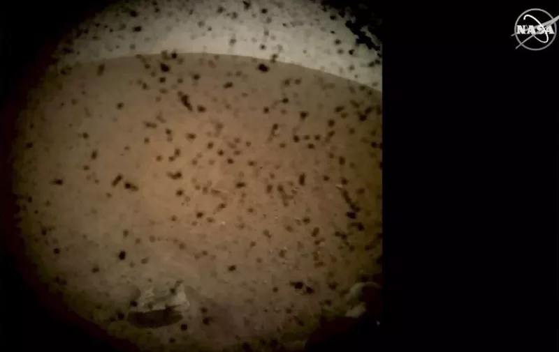 In this frame grab taken from NASA TV on November 26, 2018, debris is seen on the lens in the first image from NASA's InSight lander after it touched down on the surface of Mars. - NASA's USD 993 million Mars InSight lander has successfully touched down on the Red Planet to listen for quakes and study how rocky planets formed, the US space agency said. (Photo by HO / NASA TV / AFP) / RESTRICTED TO EDITORIAL USE - MANDATORY CREDIT "AFP PHOTO / NASA/ NASA TV- NO MARKETING NO ADVERTISING CAMPAIGNS - DISTRIBUTED AS A SERVICE TO CLIENTS