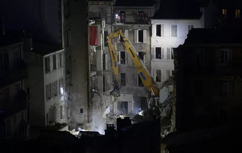 An excavator moves rubble at 'rue Tivoli' after a building collapsed in the same street, in Marseille, southern France, on April 9, 2023. - An apartment building collapsed in an apparent explosion on April 9, 2023 in the French Mediterranean city of Marseille, injuring five people, with authorities warning up to 10 victims could be under the burning rubble. (Photo by CLEMENT MAHOUDEAU / AFP)