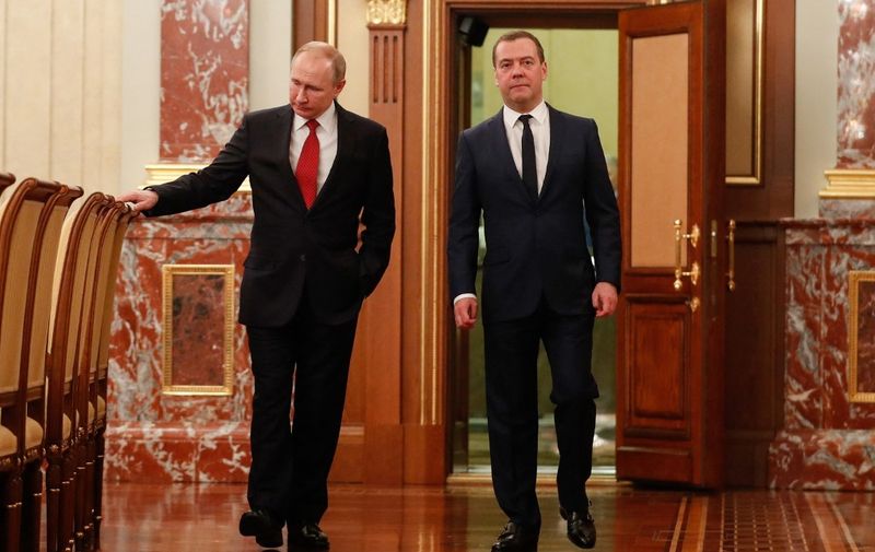 Russian President Vladimir Putin and Prime Minister Dmitry Medvedev walk before a meeting with members of the government in Moscow on January 15, 2020. - The Russian government resigned on Wednesday after President Vladimir Putin proposed a series of constitutional reforms, Russian news agencies reported. Prime Minister Dmitry Medvedev said the proposals would make significant changes to the country's balance of power and so "the government in its current form has resigned." (Photo by Dmitry ASTAKHOV / SPUTNIK / AFP)