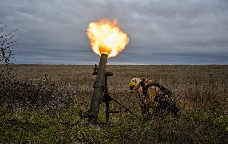 A member of Ukrainian National Guard fires a mortar launcher at a position along the front line in Kharkiv region on October 25, 2022, amid the Russian invasion of Ukraine. (Photo by SERGEY BOBOK / AFP)