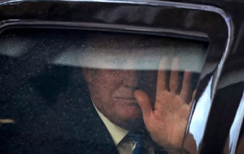 WASHINGTON, DC - JUNE 16: Republican presidential candidate Donald Trump waves from inside his vehicle as he leaves the law firm Pillsbury Winthrop Shaw Pittman after deposition June 16, 2016 in Washington, DC. Trump filed a lawsuit against chef Geoffrey Zakarian for his pulling out from establishing a restaurant at the Trump International Hotel in Washington because of TrumpÕs anti-immigrant remarks on the campaign trail.   Alex Wong/Getty Images/AFP