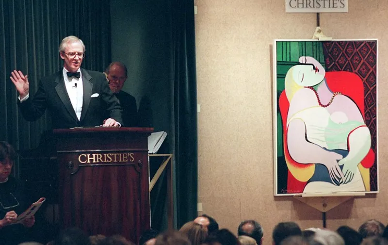Christopher Burge, chairman of Christie's (L), starts the bidding for Pablo Picasso's painting, "Le Reve", 10 November in New York at an auction of the collection of Victor and Sally Ganz. The painting, one of 58 pieces of 20th century art offered for sale, was bought for 48 million USD by an unidentified bidder. AFP PHOTO  Stan HONDA / AFP PHOTO / STAN HONDA