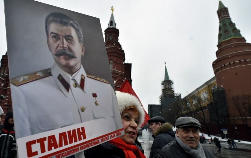 A Russian communist party supporter holds a portrait of late Soviet leader Joseph Stalin during a memorial ceremony to mark the 63rd anniversary of his death at Moscow's Red Square on March 5, 2016.
While historians blame Stalin for the deaths of millions in purges, prison camps and forced collectivization, many in Russia still praise him for leading the Soviet Union to victory over Nazi Germany in World War II. / AFP / YURI KADOBNOV