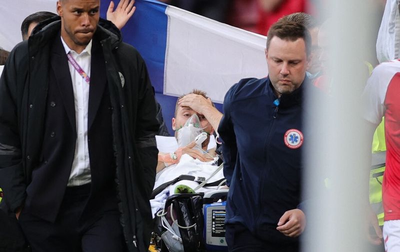 Denmark's midfielder Christian Eriksen (C) is evacuated after collapsing on the pitch during the UEFA EURO 2020 Group B football match between Denmark and Finland at the Parken Stadium in Copenhagen on June 12, 2021. (Photo by Friedemann Vogel / various sources / AFP)