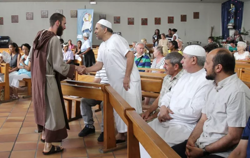A catholic monk welcomes muslim worshippers in the Saint-Pierre-de-lAriane church, prior to a mass on July 31, 2016, in Nice, southeastern France.
Muslims across France were invited to participate in Catholic Sunday service to mourn a priest whose murder by jihadist teenagers sparked fears of religious tension. Masses will be celebrated across the country in honour of octogenarian Father Jacques Hamel, whose throat was cut in his church on July 26, in the latest jihadist attack on France. 
 / AFP PHOTO / JEAN CHRISTOPHE MAGNENET