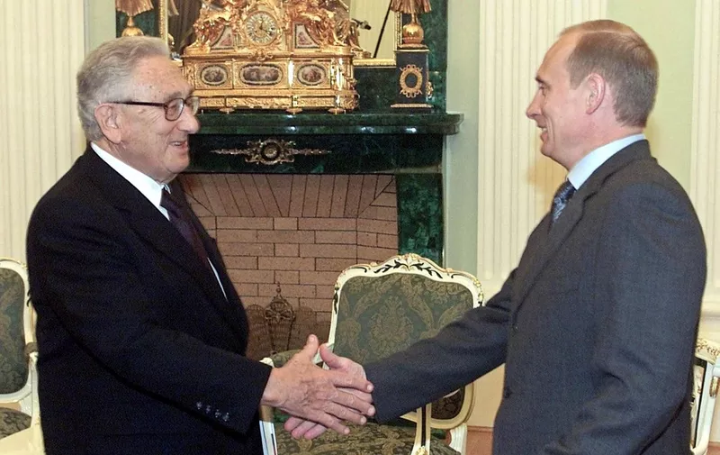 (FILES) Russian President Vladimir Putin (R) shakes hands with former U.S. Secretary of State Henry Kissinger during their meeting in the Moscow's Kremlin,13 July 2001. Former US secretary of state Henry Kissinger, a key figure of American diplomacy in the post-World War II era, died November 29, 2023 at the age of 100, his association said. (Photo by IVAN SEKRETAREV / POOL / AFP)
