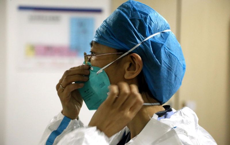 This photo taken on April 16, 2013 shows Ms. Shi, a doctor at Beijing Center of Disease Control, putting on decontamination suit before entering the laboratory in their center in Beijing. A seven-year-old girl who contracted the deadly H7N9 strain of bird flu was to leave a Beijing hospital on April 17, staff said, as the death toll from the virus in China remained at 16.  CHINA OUT   AFP PHOTO (Photo by STR / AFP)