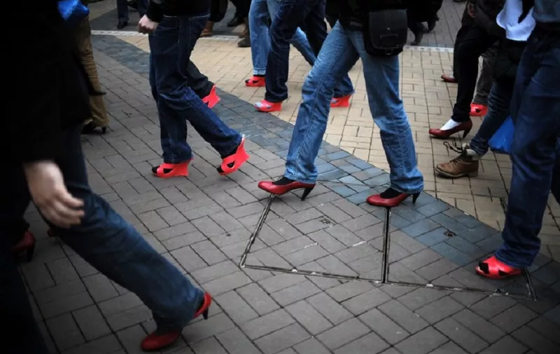 Bulgarian men wearing high heels walk during the second edition of Bulgaria's "Walk a Mile in Her Shoes", in Sofia, on March 8, 2014, as part of an international awareness campaign designed to raise awareness and stop rape, sexual assault and gender violence. AFP PHOTO / NIKOLAY DOYCHINOV / AFP PHOTO / NIKOLAY DOYCHINOV