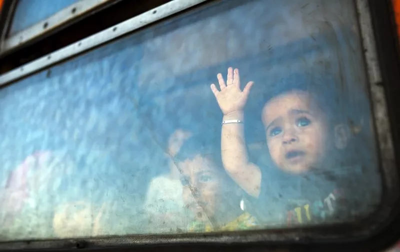 A migrant boy looks through a window onboard a train for Serbia at the new transit center for migrants at the border line between Greece and Macedonia near the town of Gevgelija on August 28, 2015. Serbia and Macedonia's foreign ministers called for EU action on Europe's migrant crisis at a summit on August 27 of leaders from the western Balkans, attended by German Chancellor Angela Merkel. Both have become major transit countries for tens of thousands of migrants trying to reach the European Union in recent months, with Macedonia last week forced to declare a state of emergency. AFP PHOTO / ROBERT ATANASOVSKI
