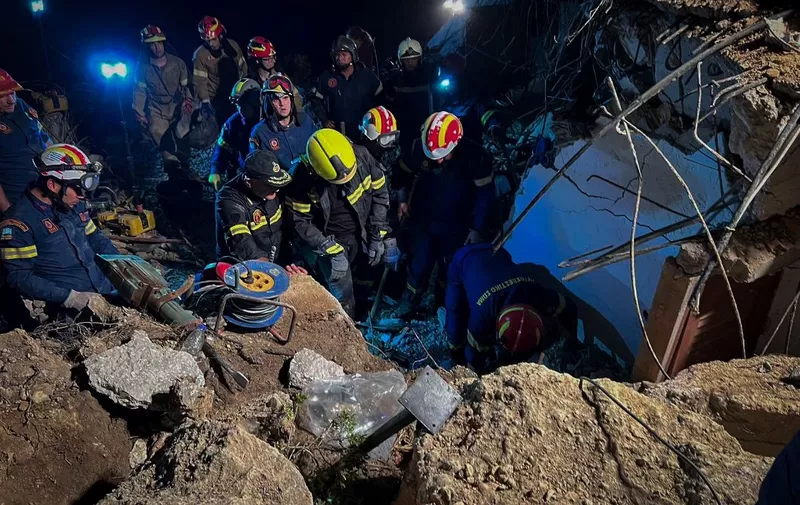 Firemen search in debris after a landslide in Agia Fotia, near Koutsounari, southeastern Crete, on October 30, 2022. - A 45-year-old tourist from the Czech Republic was killed in a landslide on the building where she was staying on the Greek island of Crete overnight from Saturday to Sunday. Her son and husband were found alive in the rubble in Agia Fotia, in southeastern Crete, Greece's largest island. (Photo by Jason Tavlas / AFP)