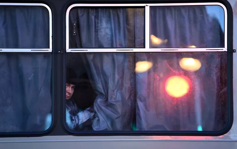 A police officer looks out from inside a police bus parked by Moscow's Pushkinskaya Square ahead of an unsanctioned protest against Russia's invasion of Ukraine on February 24, 2022. - Russian President Vladimir Putin launched a full-scale invasion of Ukraine on Thursday, killing dozens and triggering warnings from Western leaders of unprecedented sanctions. Russian air strikes hit military installations across the country and ground forces moved in from the north, south and east, forcing many Ukrainians flee their homes to the sounds of bombing. (Photo by Kirill KUDRYAVTSEV / AFP)