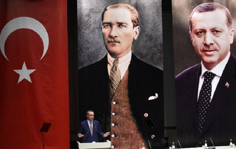 Turkey's Prime Minister Recep Tayyip Erdogan addresses members of his ruling AK Party, as he stands in front of portraits of himself (R) and Mustafa Kemal Ataturk, the founder of modern Turkey, during a meeting at his party headquarters in Ankara on May 23, 2014. AFP PHOTO / ADEM ALTAN / AFP PHOTO / ADEM ALTAN