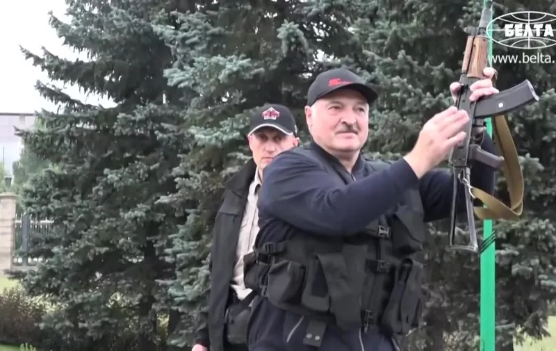 This grab taken from a video released by Belarus state agency "Belta" shows President Alexander Lukashenko holding an automatic rifle and wearing body armour as he arrives, on August 23, 2020, at his residence in Minsk, not far from where opposition protests are taking place. - Tens of thousands of demonstrators massed in central Minsk on Sunday to demand the resignation of Belarusian President Alexander Lukashenko, who flew over the scene of the banned protest in a helicopter and called the marchers "rats". (Photo by - / BELTA / AFP) / RESTRICTED TO EDITORIAL USE - MANDATORY CREDIT "AFP PHOTO / BELTA " - NO MARKETING - NO ADVERTISING CAMPAIGNS - DISTRIBUTED AS A SERVICE TO CLIENTS