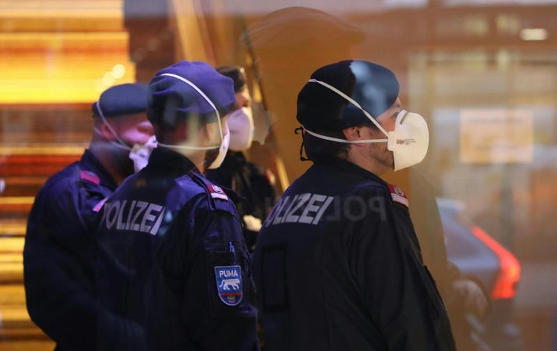 Police officers wear protective masks as they close a hotel near the city centre in Innsbruck, Austria, on February 25, 2020 after a woman who worked here has been confirmed infected with the coronavirus. - Two people in Austria have tested positive for the new coronavirus, authorities said on February 25, marking the country's first cases after an outbreak in northern Italy. (Photo by Johann GRODER / APA / AFP) / Austria OUT