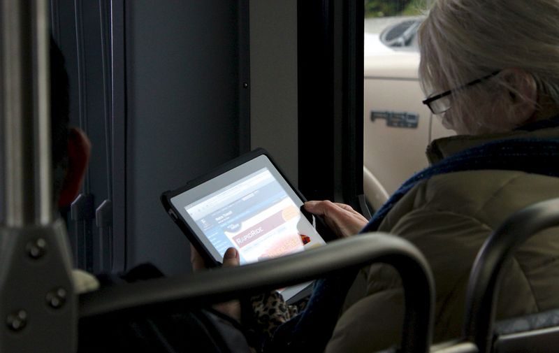 A lady views the RapidRide web site on an iPad connected to the free Wi-Fi on a B Line bus.