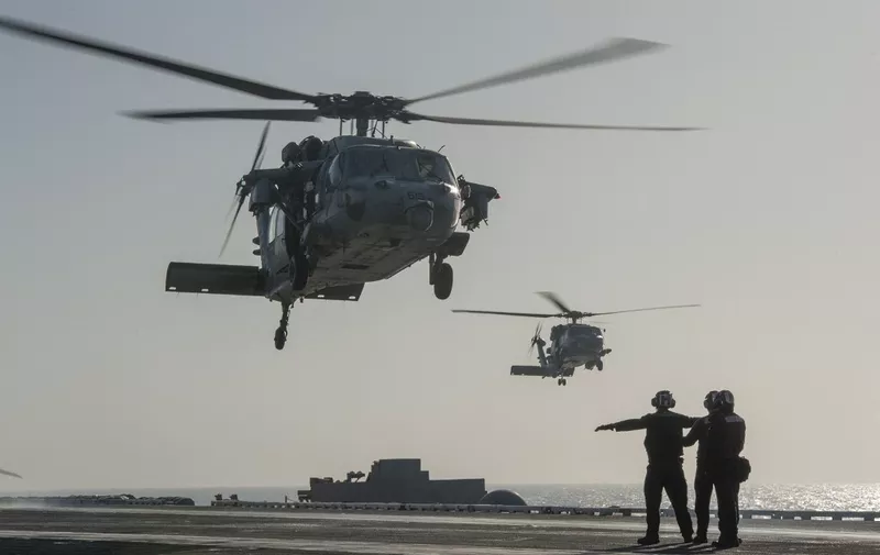 This US Navy photo released January 15, 2015 shows an MH-60S Sea Hawk helicopter from the Red Lions of Helicopter Sea Combat Squadron (HSC) 15 as it prepares to land on the flight deck of the Nimitz-class aircraft carrier USS Carl Vinson (CVN 70) on January 13, 2015 in the Gulf. Carl Vinson is deployed in the US 5th Fleet area of responsibility supporting Operation Inherent Resolve, maritime security operations, strike operations in Iraq and Syria as directed, and theater security cooperation efforts in the region. AFP PHOTO/US NAVY/JOHN PHILIP WAGNER, JR./HANDOUT (Photo by John Philip Wagner, Jr. / Navy Media Content Services / AFP)