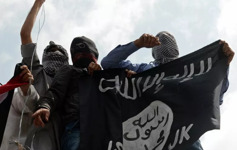 Kashmiri demonstrators hold up a flag of the Islamic State of Iraq and the Levant (ISIL) during a demonstration against Israeli military operations in Gaza, in downtown Srinagar on July 18, 2014. The death toll in Gaza hit 265 as Israel pressed a ground offensive on the 11th day of an assault aimed at stamping out rocket fire, medics said. AFP PHOTO/Tauseef MUSTAFA