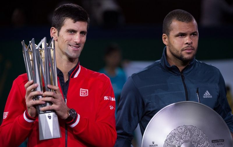 Novak Djokovic (L) of Serbia and Jo-Wilfried Tsonga of France hold their trophies after their men's singles final match at the Shanghai Masters tennis tournament in Shanghai on October 18, 2015. AFP PHOTO / JOHANNES EISELE