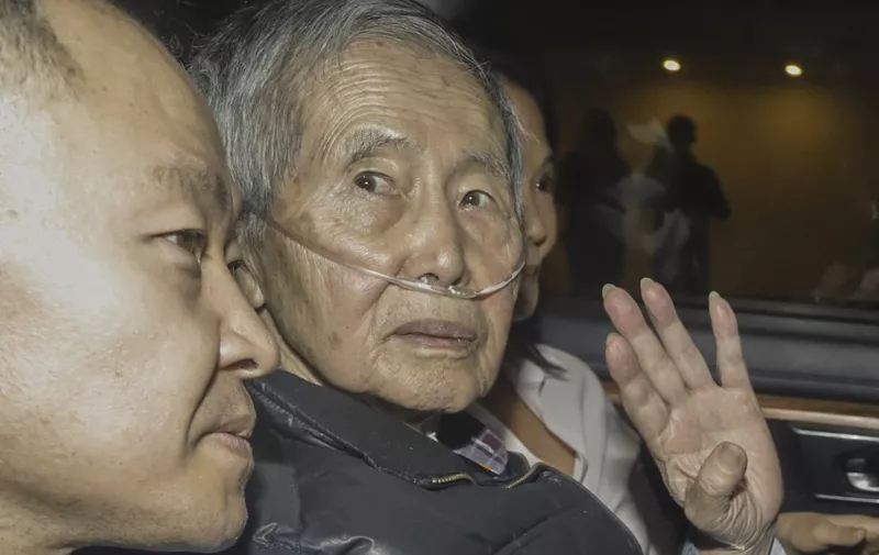 Former Peru's President (1990-2000) Alberto Fujimori sits between his children Kenji (L) and Keiko upon his release from the Barbadillo prison in the eastern outskirts of Lima, on December 6, 2023. Former Peruvian president Alberto Fujimori, 85, was freed from prison on Wednesday after a recent court order reinstated a pardon of his 25-year sentence for crimes against humanity. (Photo by Renato PAJUELO / AFP)