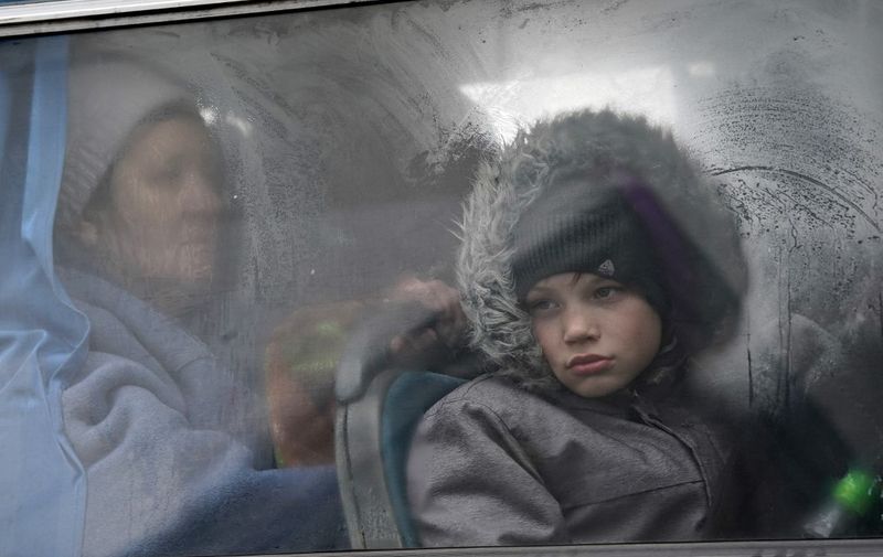 An Ukrainian boy looks out of the window of a bus in Korczowa, Poland, on March 5, 2022. - Almost 1.37 million refugees have fled Ukraine in the week since the invasion, with over half going into Poland, according to the UN refugee agency. (Photo by JANEK SKARZYNSKI / AFP)