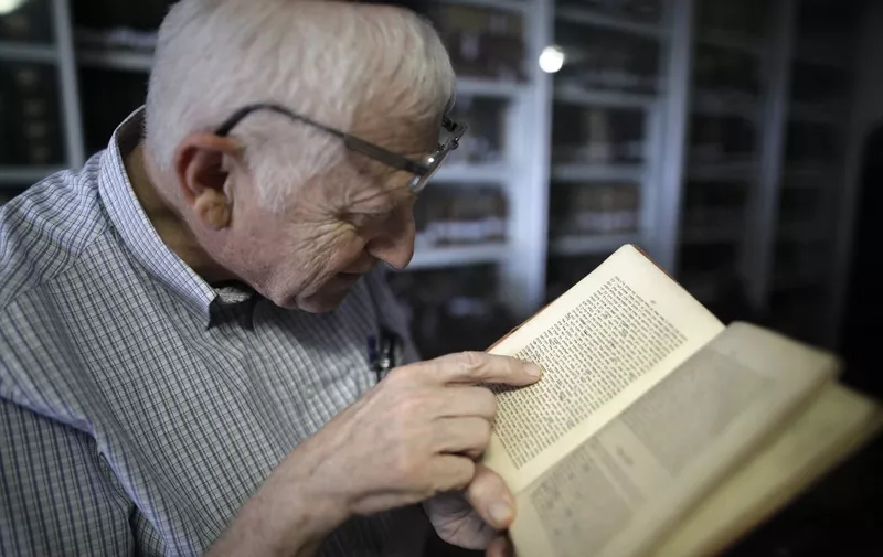 Gabriel Birnbaum, senior researcher at Historical Dictionary Project at Israel's Academy of the Hebrew Language in Jerusalem, inspects remarks in an old book at a room of the university department where books and furnitures from Eliezer Ben Yehuda, considered the father of modern Hebrew, are conserved, on August 23, 2017. Birnbaum, 66, is a senior researcher helping document and define every Hebrew word ever -- from ancient texts such as the Dead Sea Scrolls to the contemporary novels of Israeli literary figures like Amos Oz. Earlier incarnations of the language were spoken by ancient Jewish communities where the modern state of Israel is located today. After some 1,700 years, it was revived in the late 19th century as part of the push by Zionist Jews to resettle in the lands from where their ancestors fled. (Photo by MENAHEM KAHANA / AFP)
