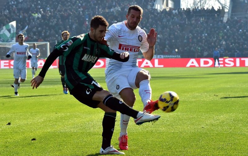 Inter Milan's German forward Lukas Podolski fights for the ball with Sassuolo's defender from Croatia Sime Vrsaljko (R) during the Serie A football match between Sassuolo and Inter Milan at "Mapei Stadium"  in Reggio Emilia  on February 1, 2015 . AFP PHOTO / GIUSEPPE CACACE