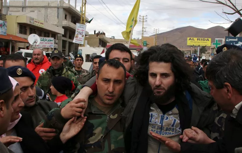 A Lebanese soldier helps a fellow member of the security forces, who has been kidnapped by jihadist groups from the eastern border town of Arsal last year, moments after his release on December 1, 2015, in the village of Labweh in the Bekaa Valley. Al-Qaeda's Syrian affiliate freed 16 Lebanese soldiers and police it had held for more than a year in exchange for the release of prisoners and delivery of aid. AFP PHOTO / STR / AFP / -