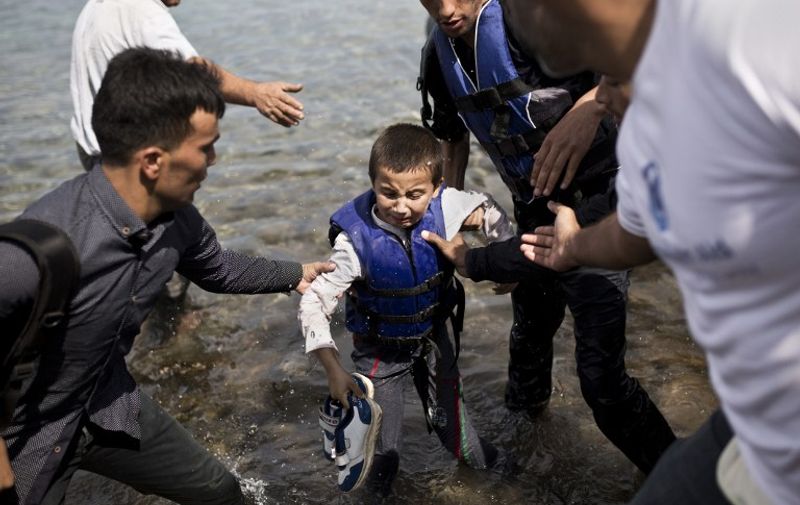 An Afghan refugee boy cries as he arrives on the shores of the Greek island of Lesbos after crossing the Aegean Sea from Turkey on a dinghy on September 9, 2015. Overwhelmed by the 20,000 refugees and migrants currently camped on the holiday island, authorities hastily set up a refugee registration centre September 8 on a parched old football pitch. Local authorities have found it impossible to keep up with the pace of the influx, and tensions have boiled over. AFP PHOTO / ANGELOS TZORTZINIS