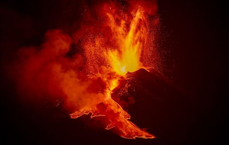 This photo taken late on February 24, 2021 in Zafferana Etnea, Sicily, shows lava flowing along the sides of the southern crater of the Etna volcano as a new eruptive episode of tall lava fountains, known as paroxysm, occurred. (Photo by Giovanni ISOLINO / AFP)