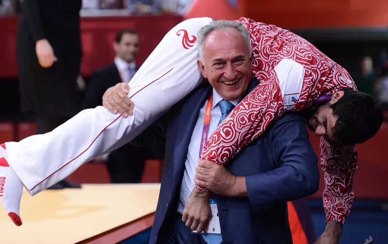 Russia's gold medalists Arsen Galstyan celebrates with Russian Judo federation president Vasily Anisimov after the podium ceremony of the men's -60 kgs contest match of the judo event at the London 2012 Olympic Games on July 28, 2012 in London. AFP PHOTO / FRANCK FIFE (Photo by FRANCK FIFE / AFP)