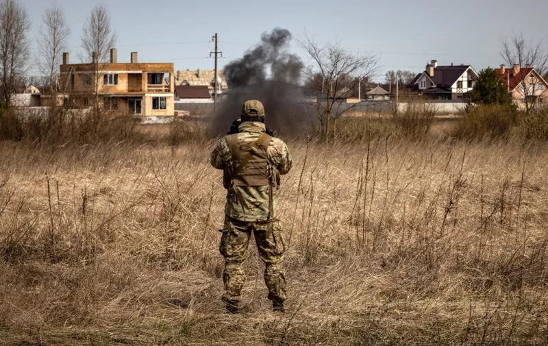 A member of a bomb disposal squad looks at smoke in a mine field near Brovary, northeast of Kyiv, on April 14, 2022, amid Russia's military invasion launched on Ukraine. - Russia called off its northern offensive to take Kyiv at the end of March, and since then Ukrainian citizens and soldiers have returned to the land they occupied. In recent weeks AFP has seen countless unexploded munitions lying in the streets of towns and villages north-east and north-west of the capital, abandoned or mislaid in the hasty withdrawal. (Photo by FADEL SENNA / AFP)