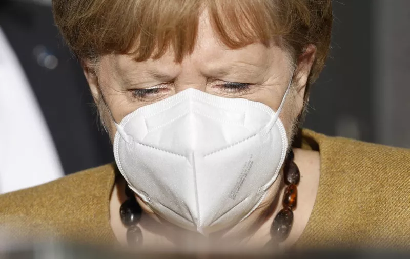 German Chancellor Angela Merkel wears a face mask as she leaves after holding a press conference on the Covid-19 situation in Germany at the house of the Federal Press Conference (Bundespressekonferenz), on January 21, 2021 in Berlin. (Photo by Odd ANDERSEN / AFP)