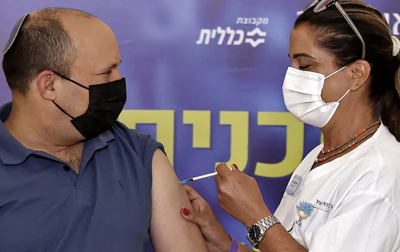 Israeli Prime Minister Naftali Bennett receives a booster shot of vaccine against the coronavirus, at Meir Medical Center in the central Israeli city of Kfar Saba, on August 20, 2021. - Bennett received a coronavirus vaccine booster shot today, as the country began administering them to people aged 40 and over amid a spike in infections. (Photo by JACK GUEZ / AFP)