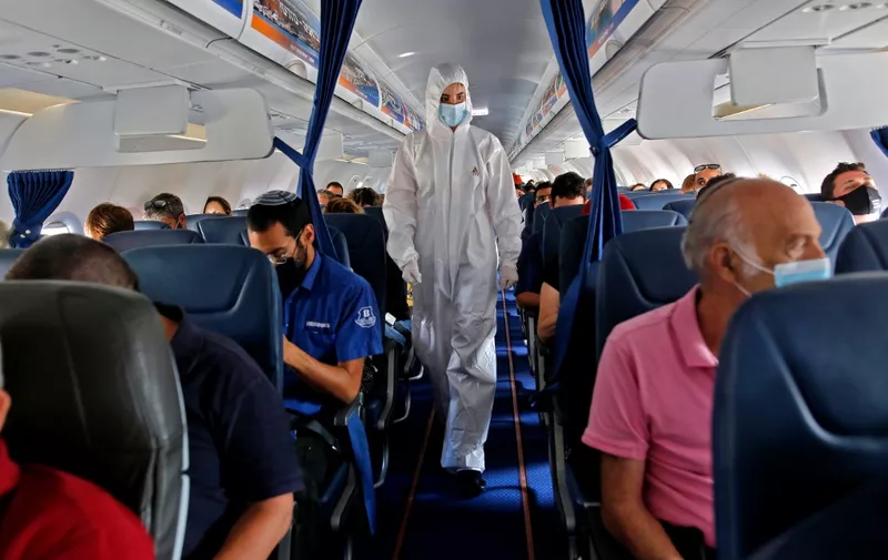 A stewardess of Israir Airlines wearing full PPE (personal protective equipment) prepares for take off from the Ben Gurion International Airport near the central Israeli city of Tel Aviv to southern Israeli Red Sea resort city of Eilat amid the COVID-19 pandemic, on June 16, 2020. (Photo by GIL COHEN-MAGEN / AFP)
