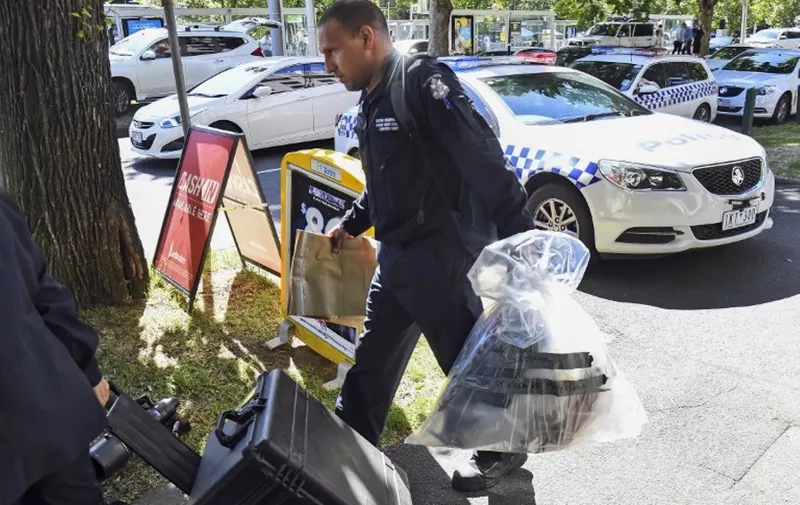 A Victoria Police forensic officer carries items to be loaded into a trailer outside the Italian consulate in Melbourne on January 9, 2019. - Australian police are investigating the delivery of suspicious packages sent to foreign embassies and consulates in Melbourne and Canberra, police and embassy sources told AFP on January 9. (Photo by William WEST / AFP)