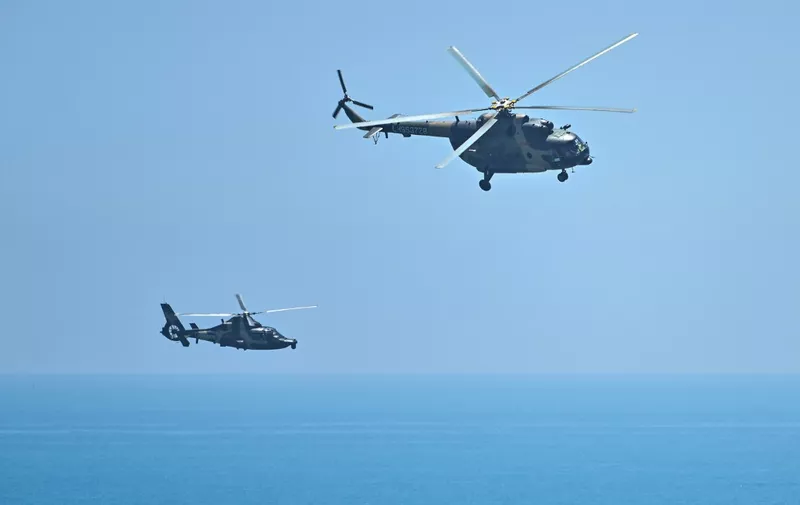 Chinese military helicopters fly past Pingtan island, one of mainland China's closest point from Taiwan, in Fujian province on August 4, 2022, ahead of massive military drills off Taiwan following US House Speaker Nancy Pelosi's visit to the self-ruled island. - China's largest-ever military exercises encircling Taiwan kicked off on August 4, in a show of force straddling vital international shipping lanes after a visit to the island by US House Speaker Nancy Pelosi. (Photo by Hector RETAMAL / AFP)