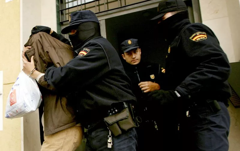A handcuffed suspect is led away by members of the Spanish Police following a raid against suspected members of a radical Islamic group in Málaga, southern Spain, 19 December 2005. Fourteen people suspected of recruiting fighters for the insurgency in Iraq were arrested overnight in a string of cities across Spain, police said Monday. They are suspected of having "recruited and indoctrinated mujaheedeen (Islamic fighters) for missions in Iraq," said a spokesman, adding that the suspects were detained in the cities of Lerida, Malaga, Nerja, Seville and on the Balearic islands.
AFP PHOTO/ JOSÉ LUIS ROCA.