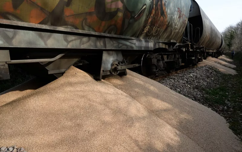 This photograph taken on March 19, 2022 shows a train after grain was spilled by members of the collective "Brittany against factory farms" ("Bretagne contre les fermes usines") on the railway line linking the Sanders Bretagne factory in Saint-Gerand, near Pontivy. - Through this commando action, the collective intends to bring down agro-industry. The sign reads against agro-industry, citizens' and farmers' response. (Photo by JEAN-FRANCOIS MONIER / AFP)