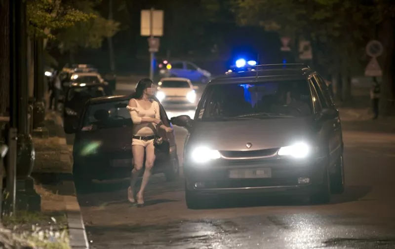 A prostitute is about to talk to a man in his car late on June 6, 2011 at the Bois de Boulogne park in Paris. AFP PHOTO / BERTRAND LANGLOIS / AFP PHOTO / BERTRAND LANGLOIS