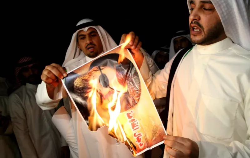 Kuwaiti protesters set ablaze a picture of Lebanese Shiite movement Hezbollah's chief Hassan Nasrallah during a protest in front the Lebanese embassy against Hezbollah's and Iran's involvement in Syria, in Kuwait city on June 11,2013. The Gulf Cooperation Council said it will take measures against members of Lebanon's Hezbollah over the Shiite movement's military intervention against Syrian rebels.  AFP PHOTO/YASSER AL-ZAYYAT / AFP / YASSER AL-ZAYYAT