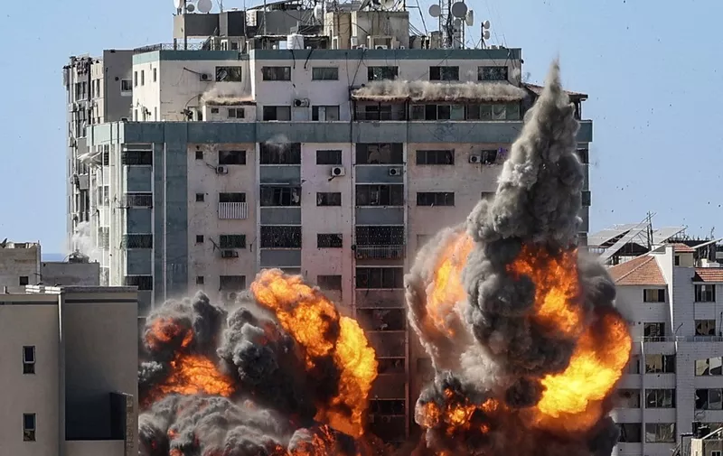 A ball of fire erupts from the Jala Tower as it is destroyed in an Israeli airstrike in Gaza City, controlled by the Palestinian Hamas movement, on May 15, 2021. - Israeli air strikes pounded the Gaza Strip, killing 10 members of an extended family and demolishing a key media building, while Palestinian militants launched rockets in return amid violence in the West Bank. Israel's air force targeted the 13-floor Jala Tower housing Qatar-based Al-Jazeera television and the Associated Press news agency. (Photo by Mahmud Hams / AFP)