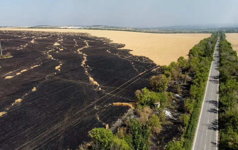 An aerial picture taken on July 8, 2022 in the countryside of Siversk, in Donetsk Oblast, eastern Ukraine, shows wheat plantations burnt following air strike attacks of the Russian army in the region. (Photo by MIGUEL MEDINA / AFP)