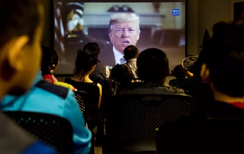 Young children watch a video message from US President Donald Trump during a US citizenship special Halloween-themed ceremony at the United States Citizenship and Immigration Services (USCIS) Washington Field Office in Fairfax, Virginia, on October 31, 2017. / AFP PHOTO / JIM WATSON