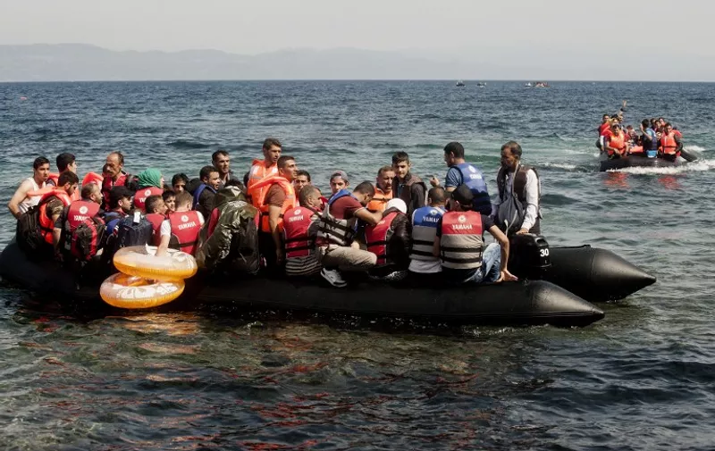 Migrants and refugees arrive on inflatable dinghies to the Greek island of Lesbos after crossing the Aegean sea from Turkey on September 26, 2015. UN Secretary-General Ban Ki-moon welcomed the European Union's decision to inject $1 billion to help countries overwhelmed by Syrian refugees, but said more must be done to relocate migrants. AFP PHOTO / IAKOVOS HATZISTAVROU