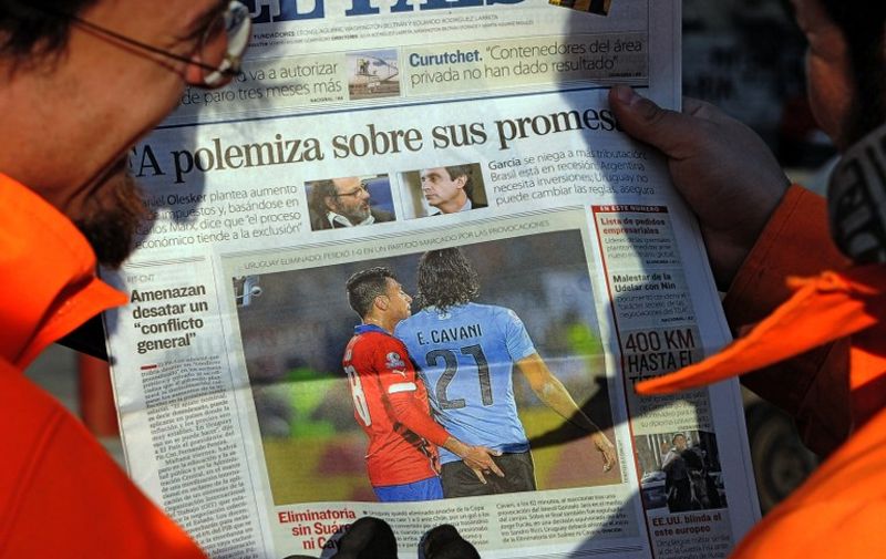 The front page of an Uruguayan newspaper shows on June 25, 2015 in Montevideo a picture of Chile's football team defender Gonzalo Jara provoking Uruguay's Edinson Cavani during their Copa America 2015 quarterfinals football match in Santiago.  Cavani was sent off midway through the second half after receiving a second yellow card for flicking a hand into the face of Jara. AFP PHOTO/MIGUEL ROJO