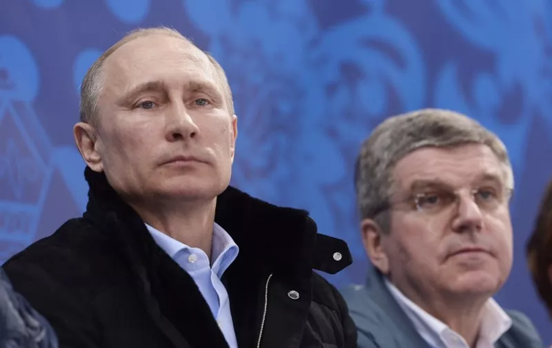 Russian President Vladimir Putin (L) and President of the International Olympic Committee Thomas Bach (R) watch a qualifying round match between the teams of Russia and the Republic of Korea in the ice sledge hockey tournament at the Sochi 2014 Winter Paralympics on March 8, 2014. AFP PHOTO / RIA NOVOSTI / POOL / ALEXEY NIKOLSKY / AFP PHOTO / RIA NOVOSTI / ALEKSEY NIKOLSKYI