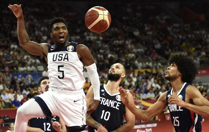 Donovan Mitchell (L) of the US reacts after scoring a basket as France's Evan Fournier (C) and Louis Labeyrie watch during the Basketball World Cup quarter-final game between US and France in Dongguan on September 11, 2019. (Photo by Ye Aung Thu / AFP)